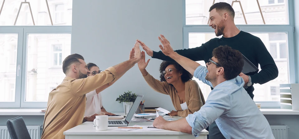 Personne utilisant un ordinateur portable dans un environnement de bureau moderne, mains positionnées sur le clavier